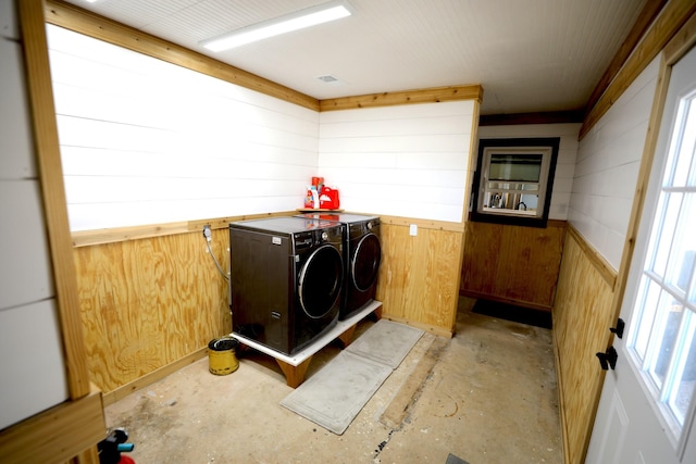 laundry room with separate washer and dryer and wooden walls