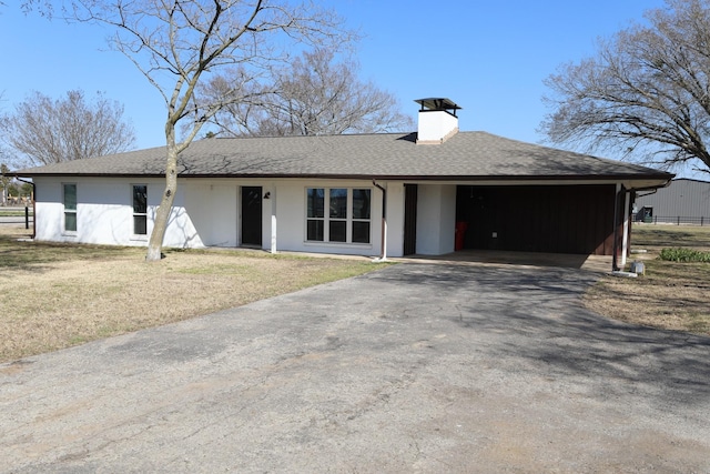 view of front of house with roof with shingles, a chimney, an attached garage, a front yard, and driveway