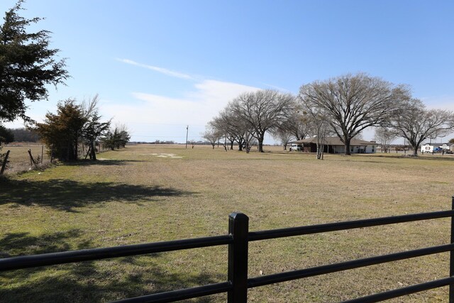 view of yard featuring a rural view and fence