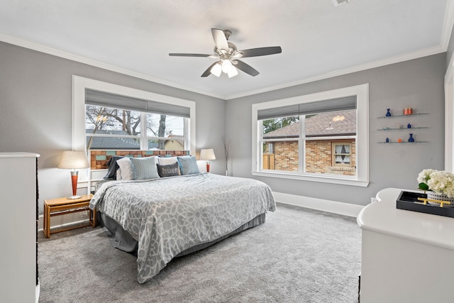 carpeted bedroom featuring ornamental molding, baseboards, and a ceiling fan