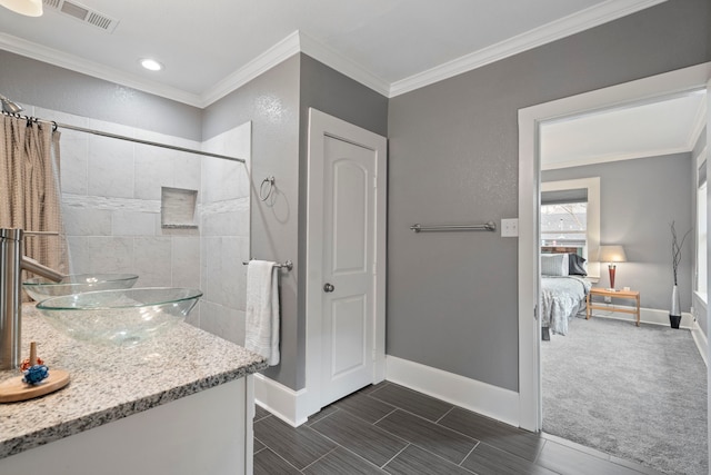 bathroom featuring ornamental molding, visible vents, and baseboards