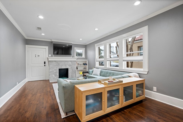 living area featuring visible vents, a fireplace, baseboards, and wood finished floors