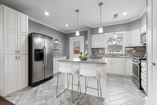 kitchen featuring open shelves, stainless steel appliances, decorative backsplash, a sink, and a kitchen island