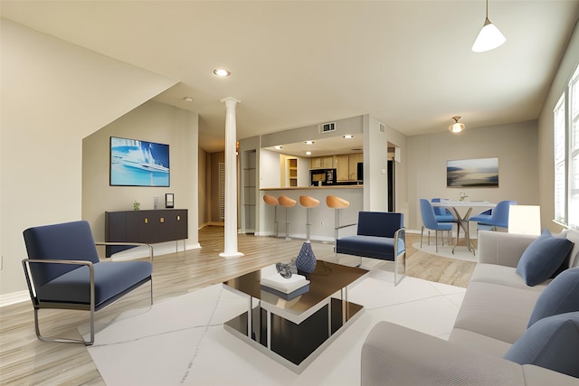 living area featuring recessed lighting, ornate columns, visible vents, light wood-style floors, and baseboards