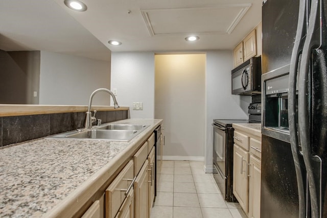 kitchen with light tile patterned floors, light countertops, light brown cabinets, a sink, and black appliances