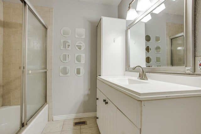 full bath with shower / bath combination with glass door, tile patterned flooring, baseboards, and vanity