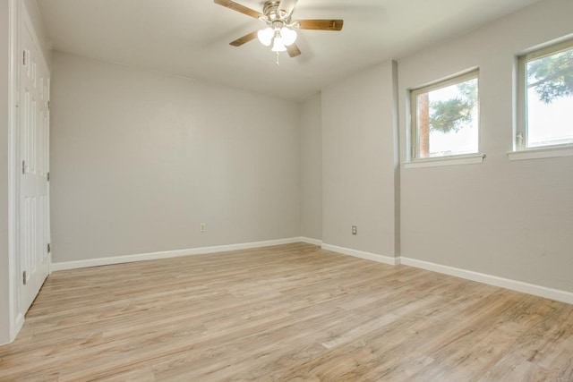 empty room featuring baseboards, ceiling fan, and light wood finished floors