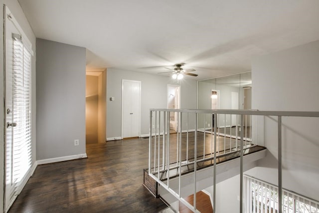 hallway with plenty of natural light, baseboards, wood finished floors, and an upstairs landing