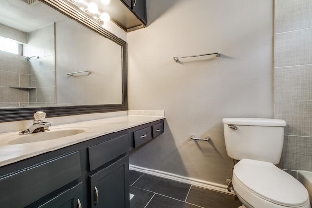 full bath featuring toilet, vanity, baseboards, and tile patterned floors