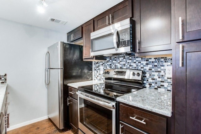 kitchen featuring dark brown cabinetry, tasteful backsplash, visible vents, and stainless steel appliances