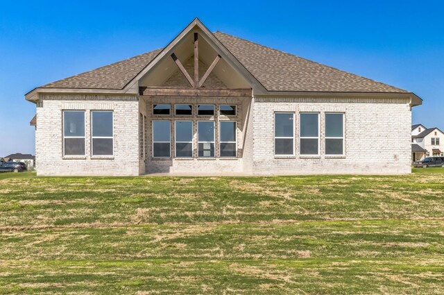 5509 Gaelic Dr, Celina, TX 75009 - rear view of house with roof with shingles, a lawn, and brick siding
