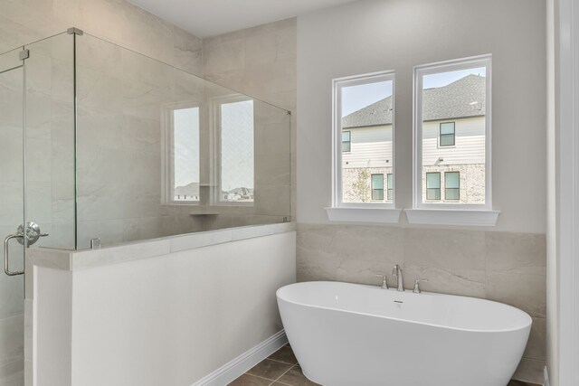 5509 Gaelic Dr, Celina, TX 75009 - full bath with a shower stall, a freestanding tub, tile patterned flooring, and tile walls