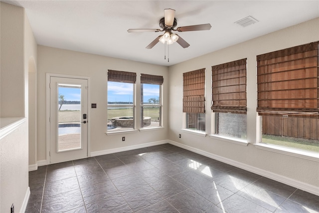 unfurnished room with a healthy amount of sunlight, baseboards, and visible vents