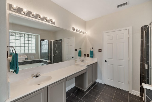 bathroom featuring double vanity, a stall shower, visible vents, tile patterned flooring, and a sink