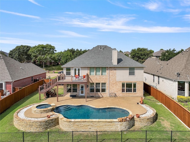 view of swimming pool featuring a pool with connected hot tub, a patio area, a fenced backyard, and a yard