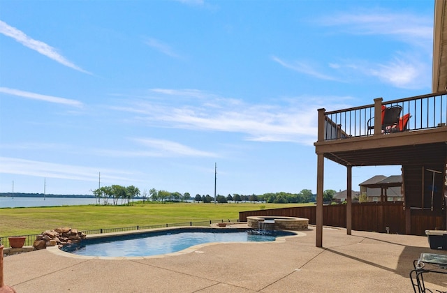 view of swimming pool featuring a patio area, a pool with connected hot tub, a lawn, and a deck with water view