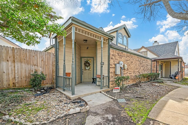 view of front of house featuring covered porch and fence