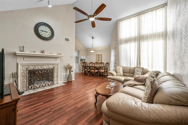 living room with a healthy amount of sunlight, visible vents, wood finished floors, and a tile fireplace