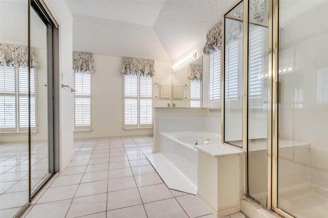 full bath featuring tile patterned floors, a garden tub, vaulted ceiling, a textured ceiling, and a shower stall