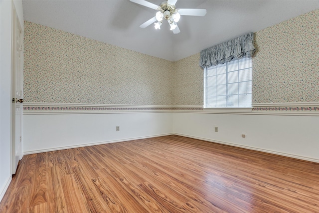 unfurnished room featuring a ceiling fan, wallpapered walls, baseboards, and wood finished floors