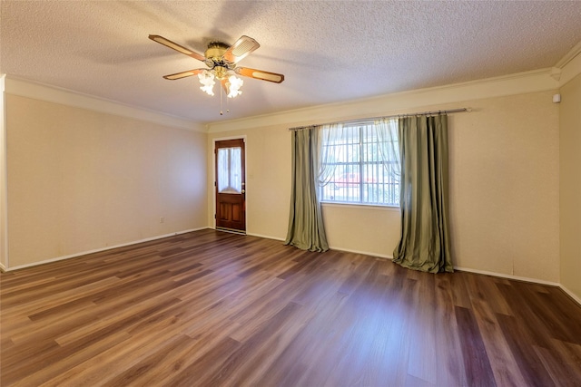 spare room featuring ornamental molding, a ceiling fan, a textured ceiling, wood finished floors, and baseboards