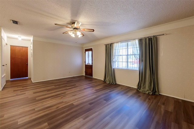 empty room featuring visible vents, ornamental molding, ceiling fan, a textured ceiling, and wood finished floors