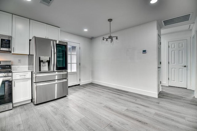 kitchen with stainless steel appliances, visible vents, white cabinetry, light countertops, and light wood-type flooring