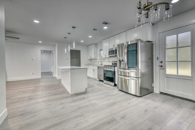 kitchen featuring light countertops, appliances with stainless steel finishes, visible vents, and white cabinetry