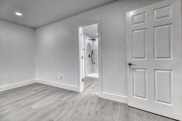 spare room with baseboards and wood finished floors