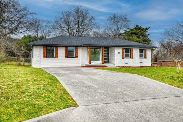 ranch-style home featuring a front yard, crawl space, brick siding, and fence