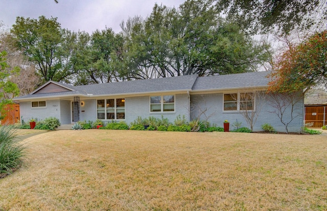 single story home with brick siding and a front yard