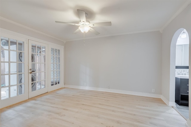 spare room with french doors, ornamental molding, a ceiling fan, light wood-type flooring, and baseboards