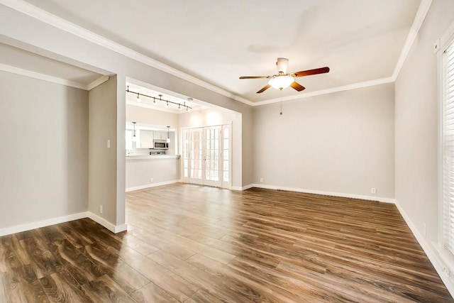 unfurnished room featuring baseboards, dark wood finished floors, and crown molding