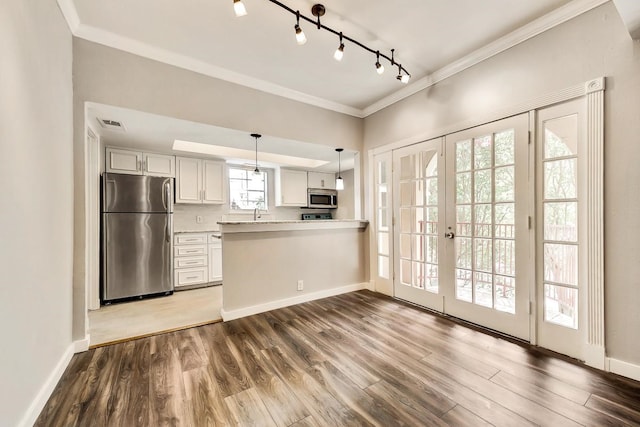 kitchen featuring stainless steel appliances, french doors, dark wood-style flooring, and crown molding