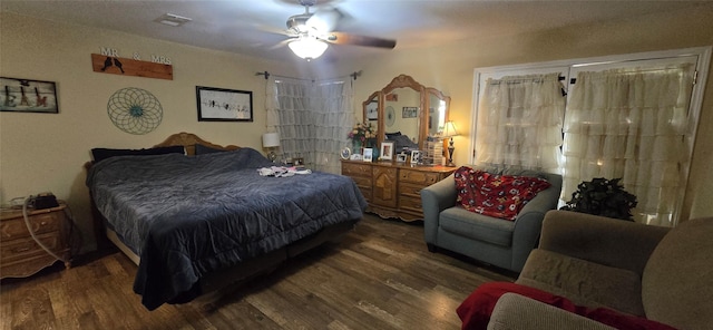 bedroom with a ceiling fan, visible vents, and wood finished floors