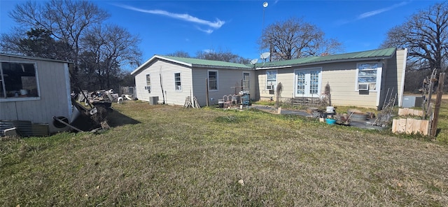 back of house featuring metal roof and a yard