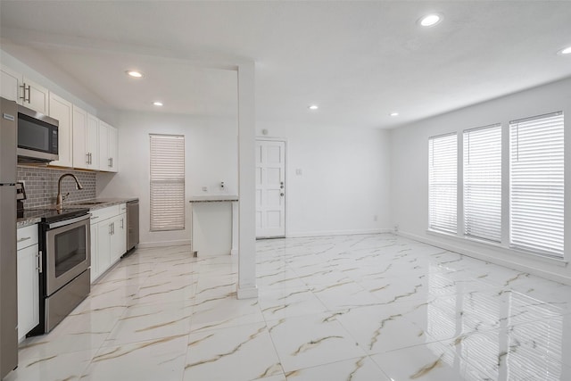 kitchen with marble finish floor, stainless steel appliances, tasteful backsplash, and a sink