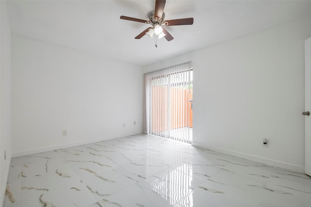 spare room featuring marble finish floor, ceiling fan, and baseboards