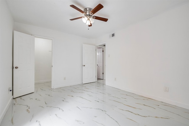 unfurnished bedroom with a ceiling fan, visible vents, baseboards, marble finish floor, and a walk in closet