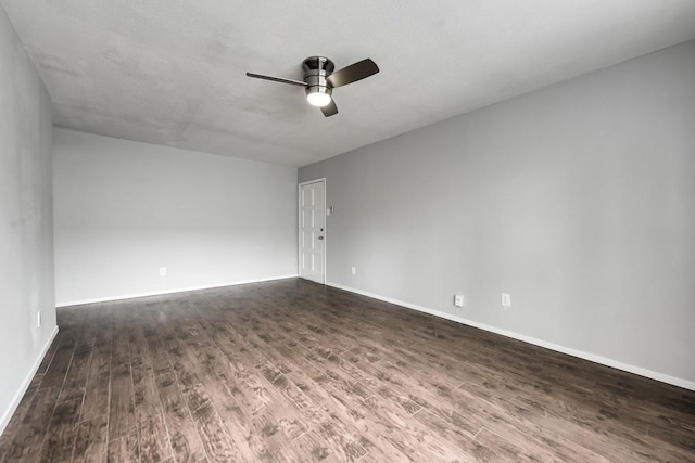 empty room with ceiling fan, baseboards, dark wood finished floors, and a textured ceiling