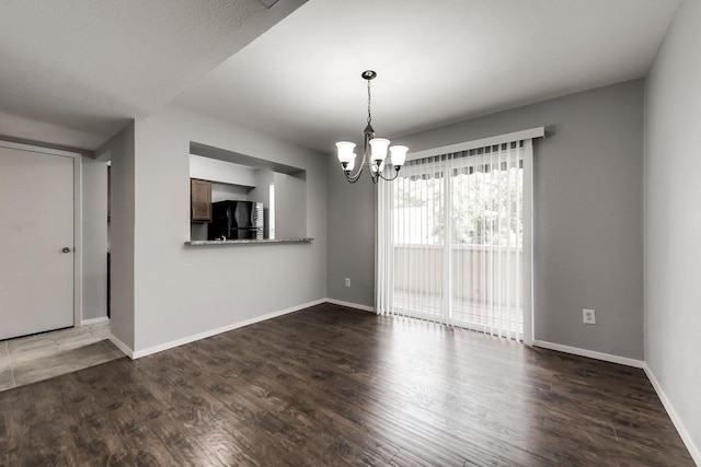 interior space featuring baseboards, a chandelier, and wood finished floors