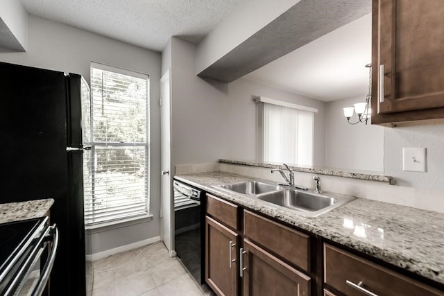 kitchen featuring light tile patterned flooring, a sink, a textured ceiling, black appliances, and baseboards