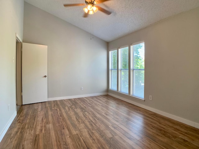 spare room featuring a ceiling fan, lofted ceiling, a textured ceiling, and wood finished floors