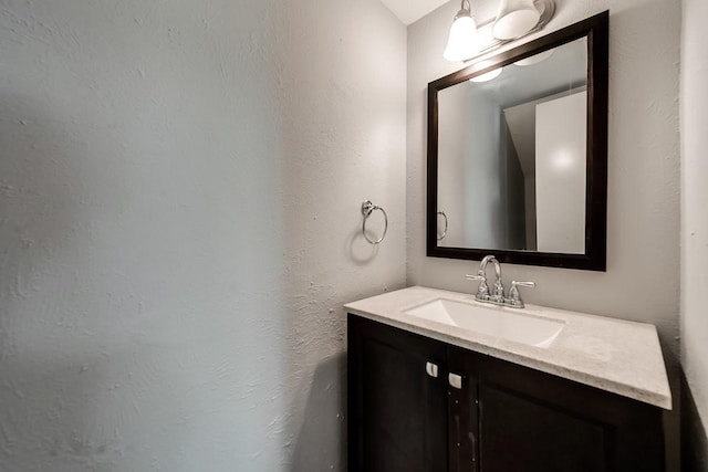 bathroom featuring a textured wall and vanity