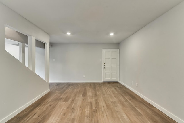 unfurnished room with baseboards, wood finished floors, and recessed lighting