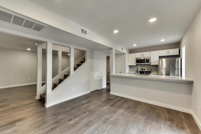 kitchen featuring a sink, visible vents, white cabinetry, appliances with stainless steel finishes, and dark wood finished floors