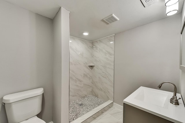 bathroom with toilet, marble finish floor, tiled shower, and visible vents