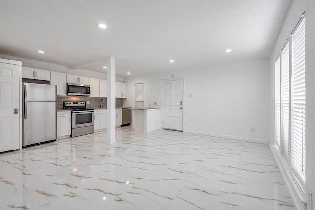 kitchen featuring recessed lighting, backsplash, appliances with stainless steel finishes, open floor plan, and white cabinets