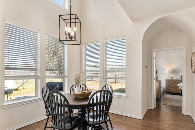 dining area with wood finished floors, baseboards, and a chandelier