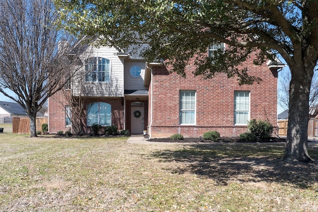 traditional-style home with brick siding and a front yard